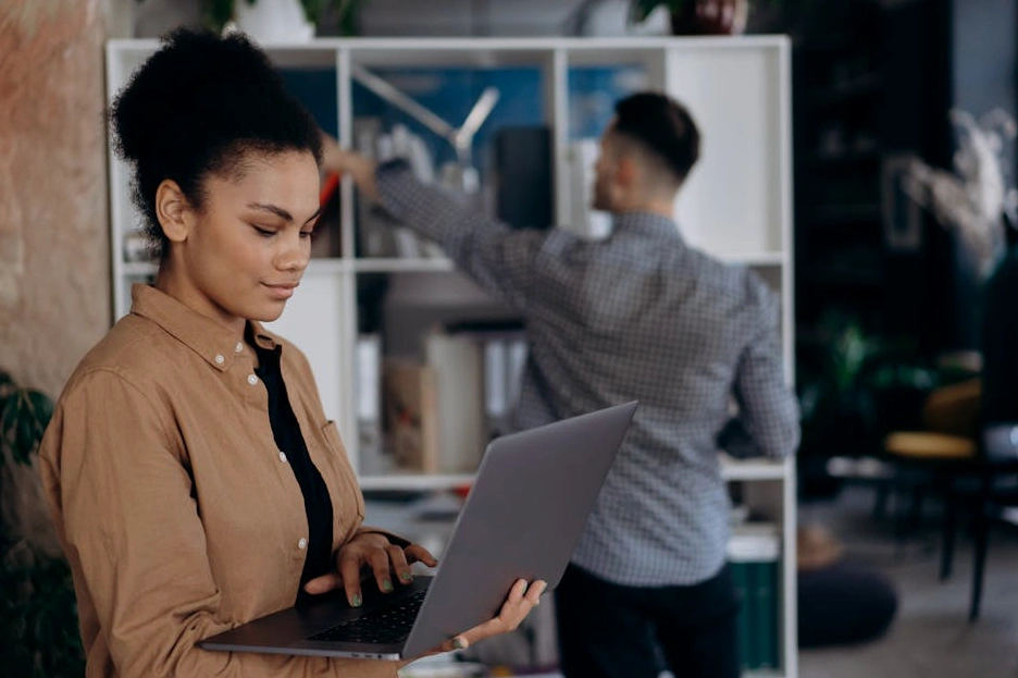 An adult carefully reviewing financial documents at a well-organized desk.